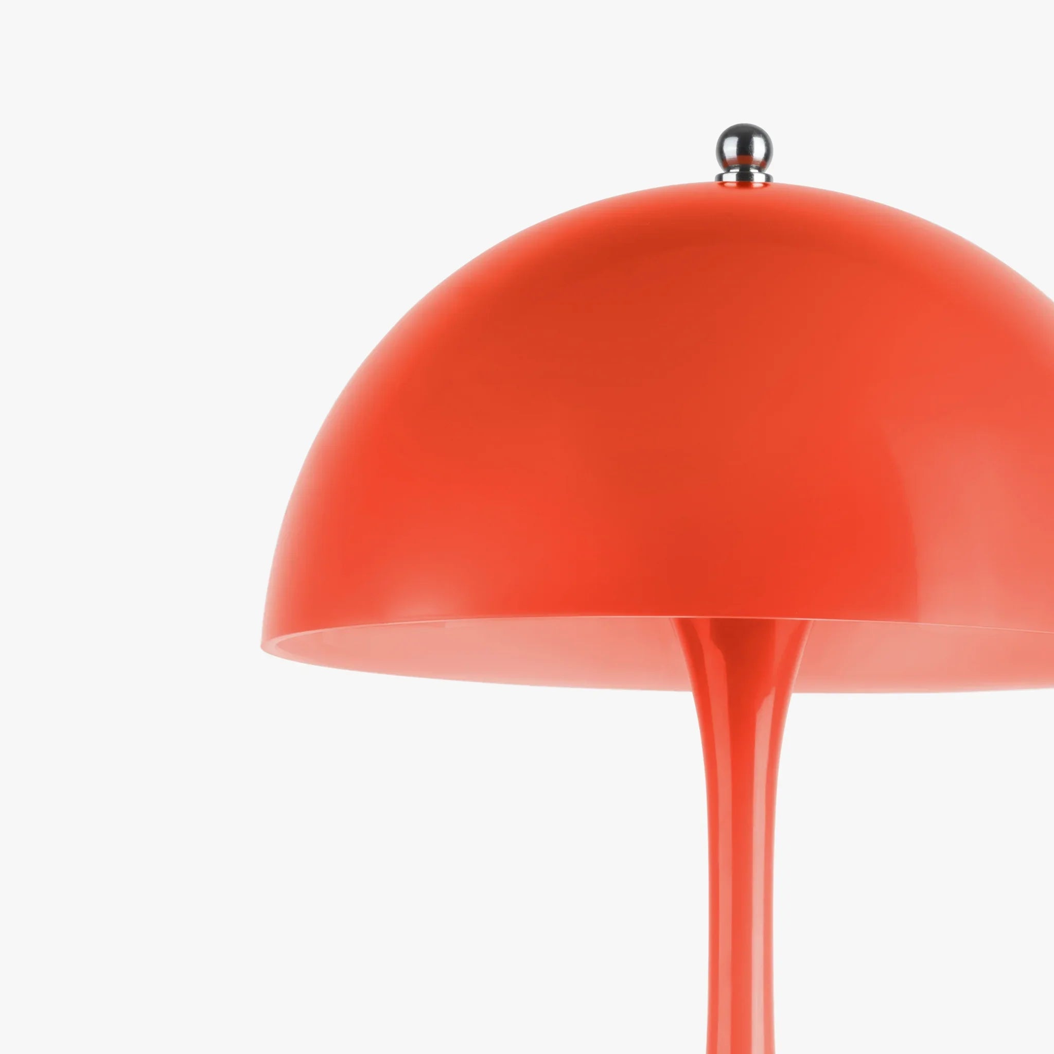 Vibrant orange dome lamp with sleek stem and chrome finial, perfect for funky home decor.