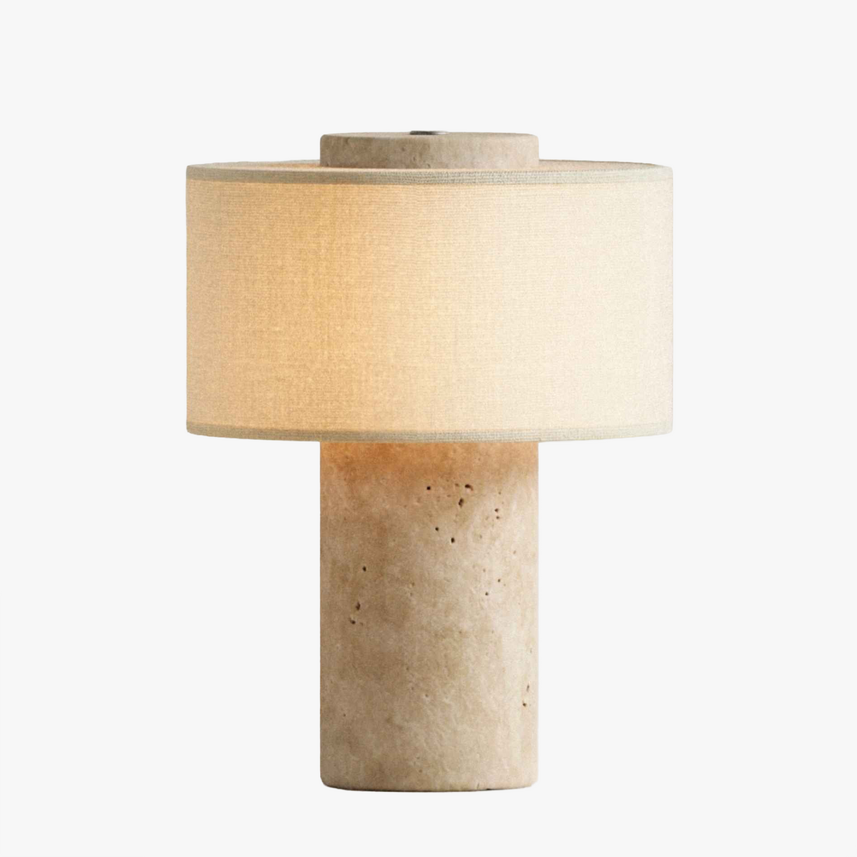 Olbia Portable Lamp in Travertine Stone, a cordless stone table lamp with a fabric drum shade, light on, front view