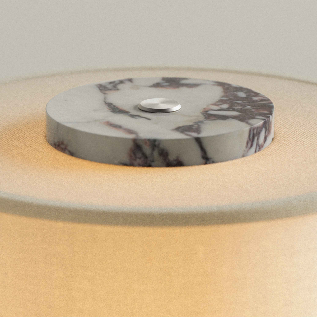 Cream Burgundy Marble cap with touch button on top of the Olbia Portable Lamp's glowing drum shade