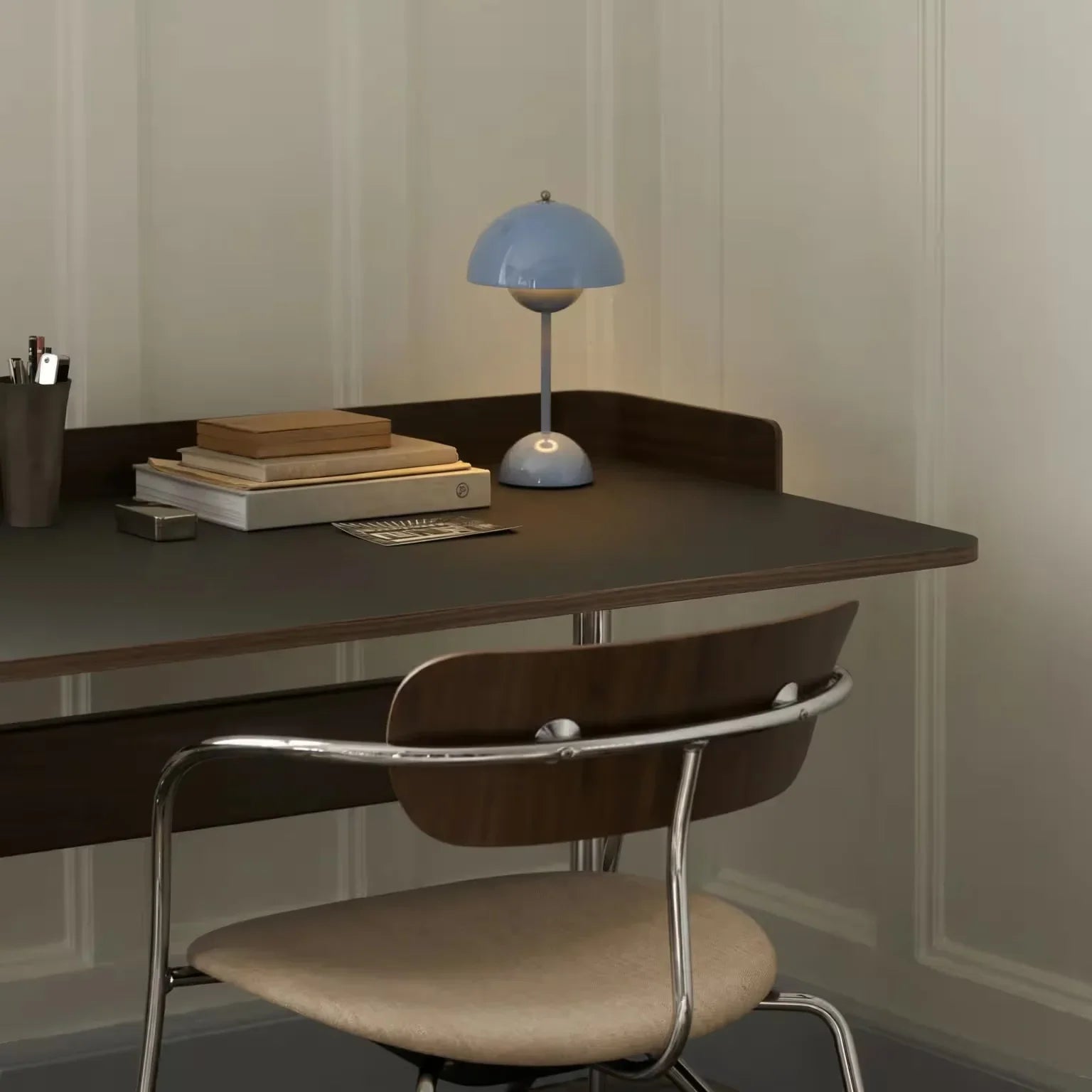 Blue dome desk lamp on modern workspace with books and chair, groovy lighting for home office