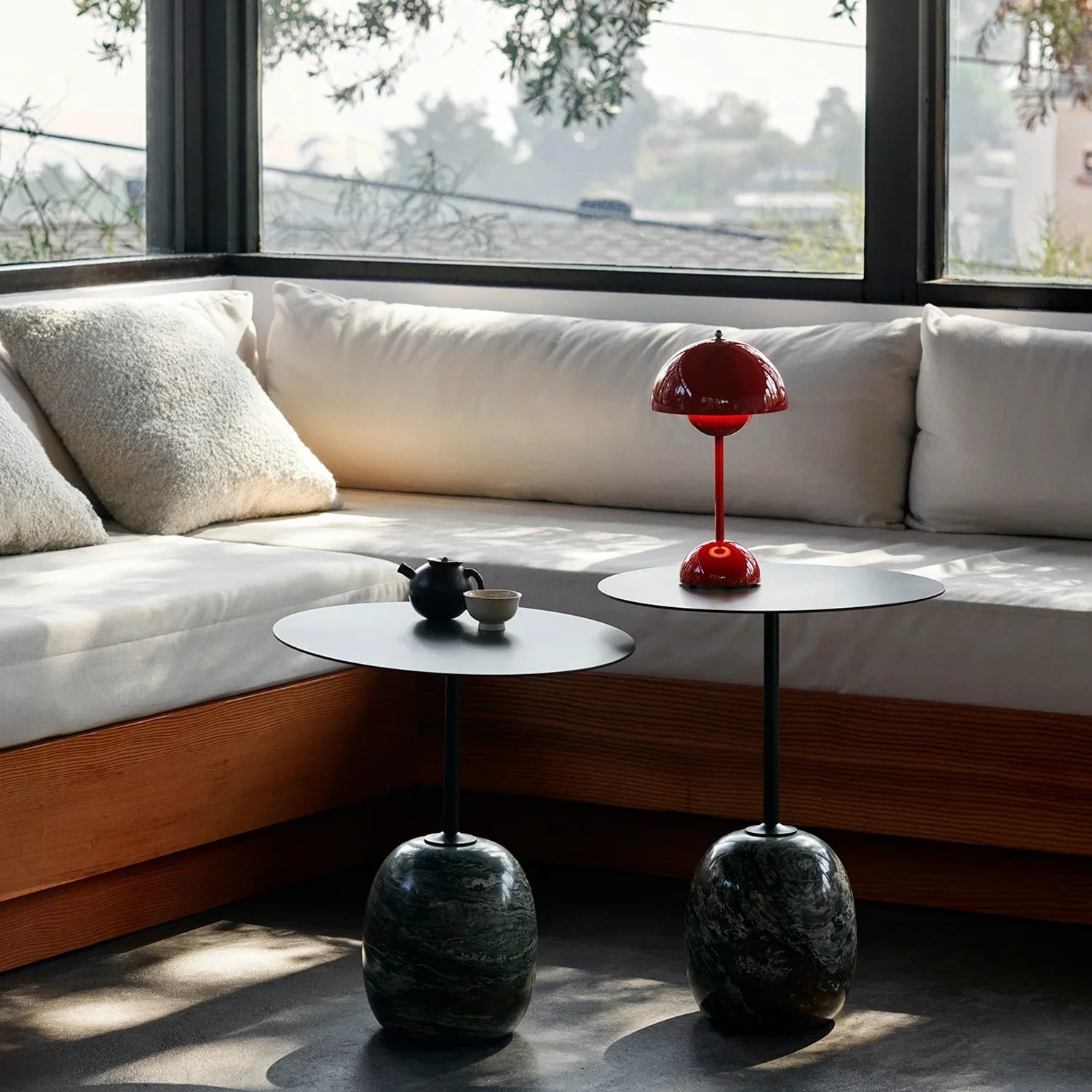Red mushroom-style table lamp on marble base beside cozy white sofa, perfect for groovy home decor