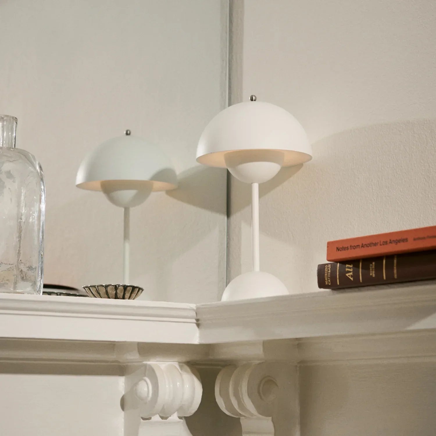 White modern table lamp on mantel with books, minimalist decor